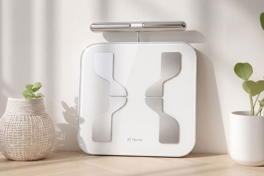 White Hume Pod 2.0 beside plants on a wooden surface